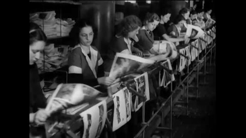 CIRCA 1937 - Women hang the covers of newly-printed issues of Life Magazine on racks to dry at a factory.