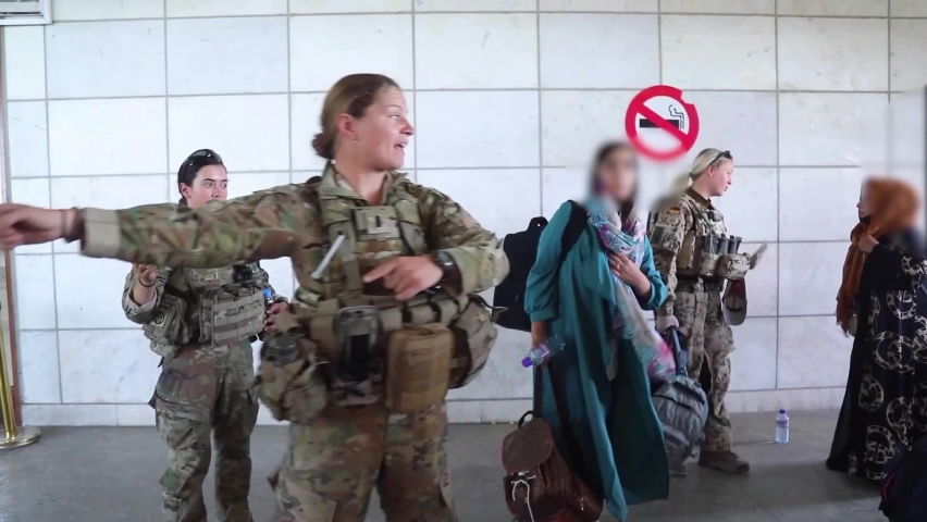 CIRCA 2021 - Afghan refugees are ushered onto planes by U.S. soldiers at Hamid Karzai airport during the mass evacuation effort of Afghanistan.