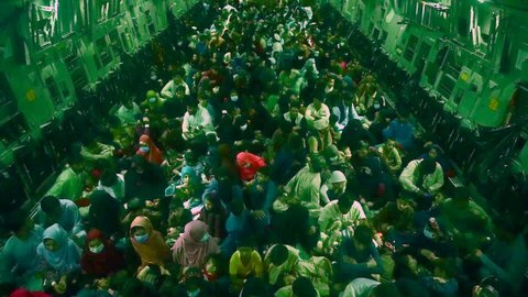 CIRCA 2021 - hundreds of Afghan refugees sit in the cargo hold of an American C-17 Globemaster during the American evacuation of Afghanistan.