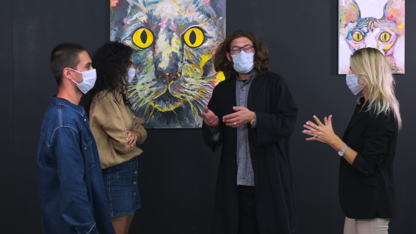 people with face masks are viewing exhibition with guide in fine art gallery, group of art lovers are visiting modern museum during pandemic, listening to artist or art critic