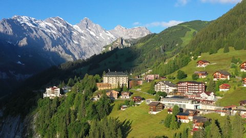 Rotating drone shot of Murren, a traditional Walser mountain village in the Bernese Highlands of Switzerland. Homes and hotels with mountains in the distance