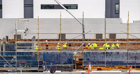 Brisbane, Australia - Aug 31, 2021: Construction workers pouring concrete on a site