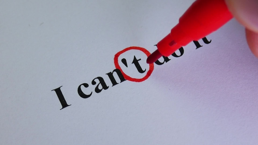 Hand crosses out part of text on white paper. Motivation for business. unrecognizable hand person wtite words I CAN'T DO IT. Concept for self belief, positive attitude. 