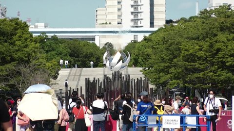 TOKYO, JAPAN - AUGUST 2021 : View of the Olympic Torch Flame Stand (Tokyo 2020 Summer Olympic Games) at Ariake area. Crowd of people wearing mask and taking photo or video. Slow motion shot.