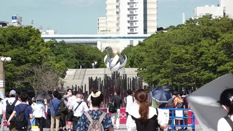 TOKYO, JAPAN - AUGUST 2021 : View of the Olympic Torch Flame Stand (Tokyo 2020 Summer Olympic Games) at Yume no Ohashi, Ariake area. Crowd of people wearing mask and taking photo or video.