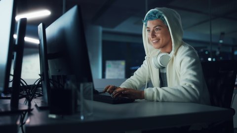 Late at Night in Office: Portrait of Young Stylish Freelancer Woman Working on Desktop Computer. Blue Haired Person Creating Modern Content, Does Project Design, Creates Colorful Marketing and Smile