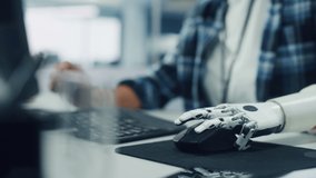 Inclusive Office: Person with Disability Using Prosthetic Arm to Work on Computer. Professional with Advanced Thought Controlled Body Powered Myoelectric Bionic Limb to Control Mouse. Focus on Hands - Powered by Shutterstock - Get 15% off with code: PIKWIZARD15