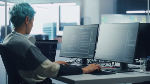 In Diverse Office: Female Programmer is Working on Desktop Computer, Screen Shows Coding Language User Interface. Digital Entrepreneur Creating Modern Software, e-Commerce App Design. Over Shoulder