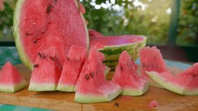 juicy fresh watermelon cut by hand on wooden board with kitchen knife on a terrace, summer vegan food, refreshment, fruit dessert. High quality 4k footage