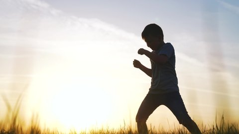 silhouette child kid boxer. boy a boxing with shadow exercising at sunset outdoor. kid sun dream. sport victory healthy lifestyle concept. child shadow boxing little champion boxer silhouette