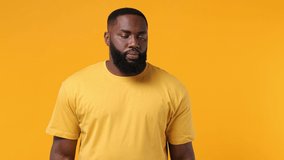 Cheery smiling happy fun young bearded african american man 20s wears orange t-shirt doing selfie shot on mobile phone post photo on social network isolated on plain yellow background studio portrait