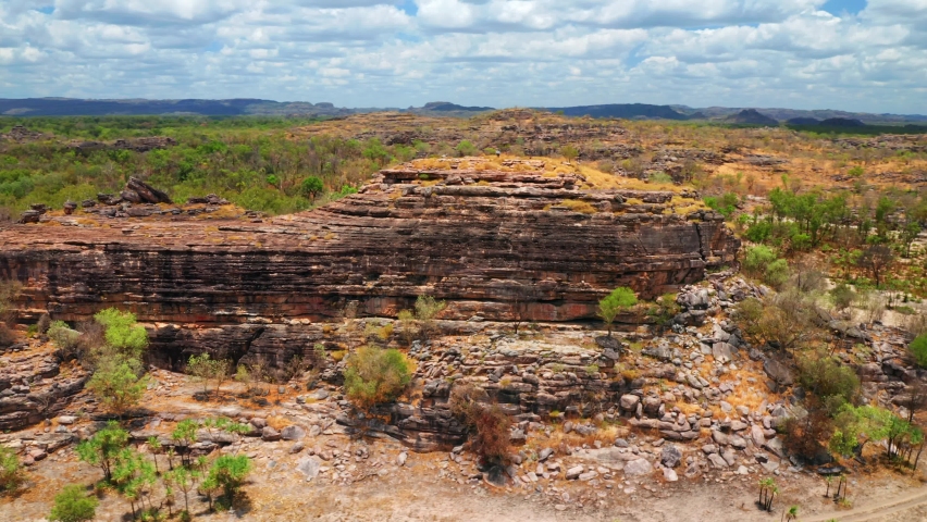 Ancient Rocky Outcrop Of Ubirr With Person Standing On Top - Kakadu National Park, Northern Territory, Australia. - Aerial Orbit Royalty-Free Stock Footage #1078445954
