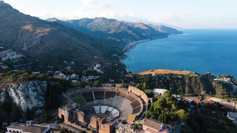 Taormina, Sicily, Italy - drone shot of the cityscape and amphitheater while sunset.