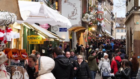 Strasbourg, France - Circa 2019: Busy street during Annual Christmas market decorations before COVID-19 pandemics - large crowd of people from all over the world visiting the Christmas Capital