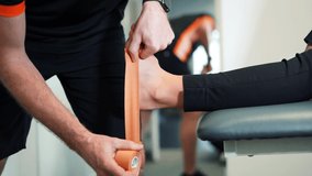 Physiotherapist strapping ankle for sport - Powered by Shutterstock - Get 15% off with code: PIKWIZARD15