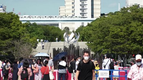 TOKYO, JAPAN - AUGUST 2021 : View of the Olympic Torch Flame Stand (Tokyo 2020 Summer Olympic Games) at Ariake area. Crowd of people wearing mask and taking photo or video. Slow motion shot.
