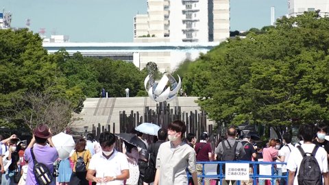 TOKYO, JAPAN - AUGUST 2021 : View of the Olympic Torch Flame Stand (Tokyo 2020 Summer Olympic Games) at Yume no Ohashi, Ariake area. Crowd of people wearing mask and taking photo or video.