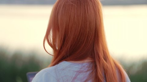 a red-haired woman at sunset, a close female portrait