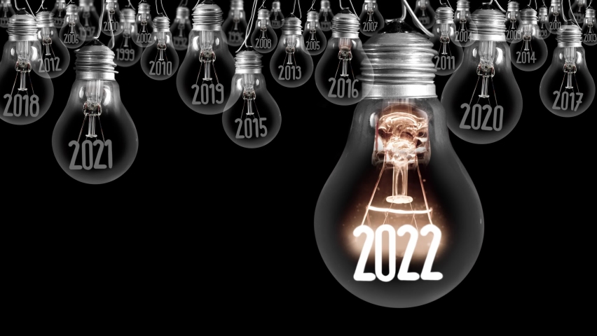 Shining light bulb with New Year 2022 and group of dark light bulbs with years passed isolated on black background. Seamless looping. High quality 4k video. Royalty-Free Stock Footage #1078475240