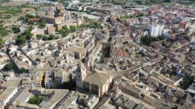 Aerial view of fortified castle and Basilica of Vera Cruz on hill dominating residential areas of Spanish town of Caravaca de la Cruz on summer day. High quality 4k footage
