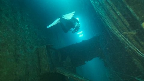 MEDITERRANEAN SEA, CYPRUS - AUGUST, 2021: Scuba diver swims inside of the shipwreck Swedish ferry MS Zenobia. Wreck diving in Mediterranean sea 