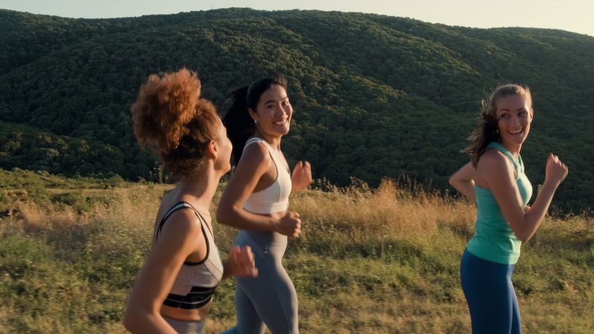 Group of female friends running outdoors.