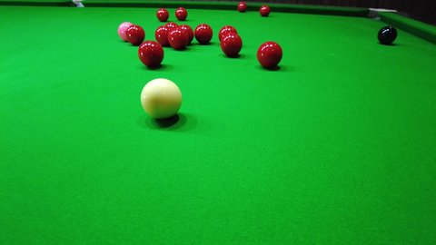 Snooker player do stunning shot ,  cue ball strike red ball into the snooker table pocket , successfully shot , indoor sport concept , 4K 59.94 fps footage