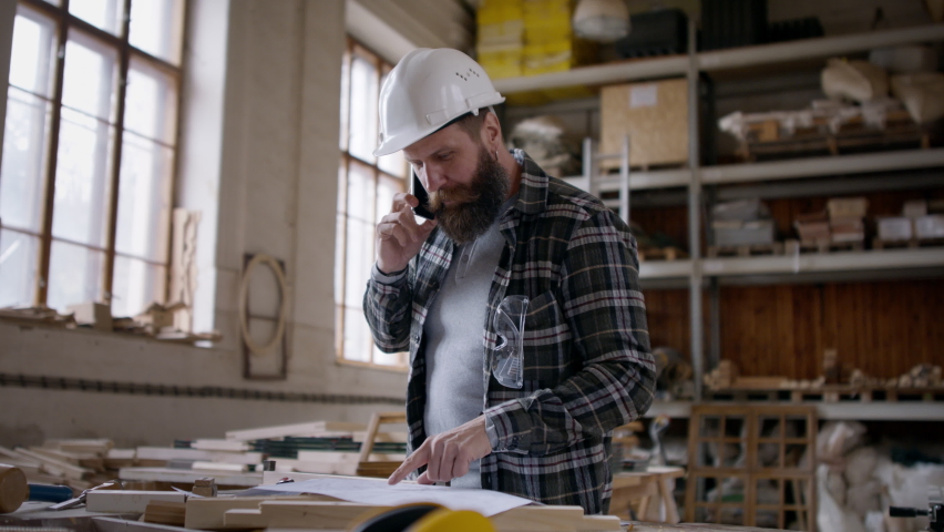 Male carpenter having a call, discussing desing of product. Small business concept.