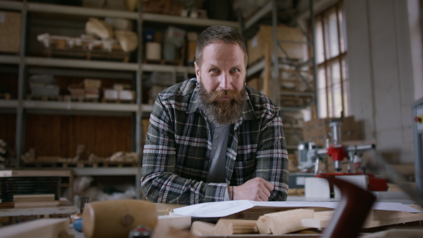 Male carpenter sketching desing of his product, looking at camera. Small business concept.