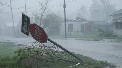 Hurricane Ida Blows Over Stop Sign With A Damaged Home In the Background In Houma, Louisiana USA During Category 4 Storm