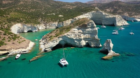 Aerial drone video of Kleftiko a beautiful scenic white volcanic rock formation bay visited by sail boats and yachts with turquoise crystal clear sea and caves, Sea Meteora of Greece, Milos island