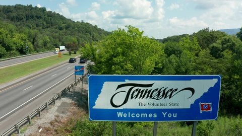 State Line , TN , United States - 08 11 2021: Welcome to Tennessee sign along interstate highway. TN, USA. Descending aerial.
