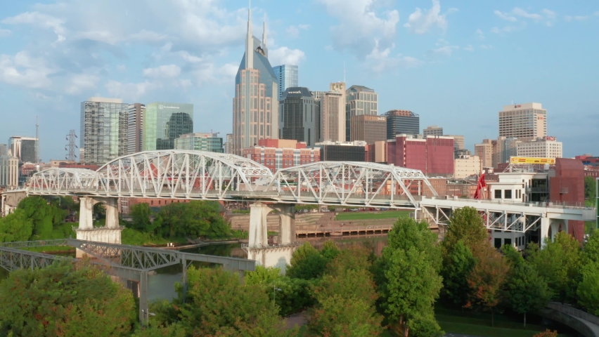 Nashville TN skyline. Rising aerial establishing shot of Cumberland River waterfront in summer.