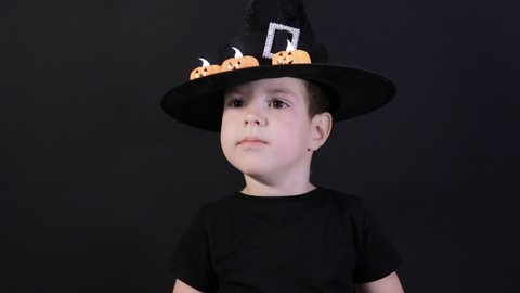 A small child boy of 4 years in a sorcerer's costume is preparing for Halloween. Holiday in kindergarten.