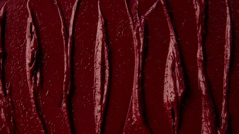 Texture of red lipstick close up. Spatula and red paint. Advertising of decorative cosmetics. Advertising concept. Move with a spatula on a red texture. Red color.