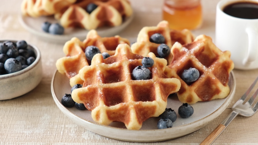 Pouring molasses, amber maple syrup on belgian waffles served with blueberries. Sweet breakfast or dessert closeup view. Tasty food shot Royalty-Free Stock Footage #1078529459