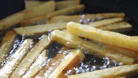 french fries in a pan, frying potatoes in the hot oil, close up view