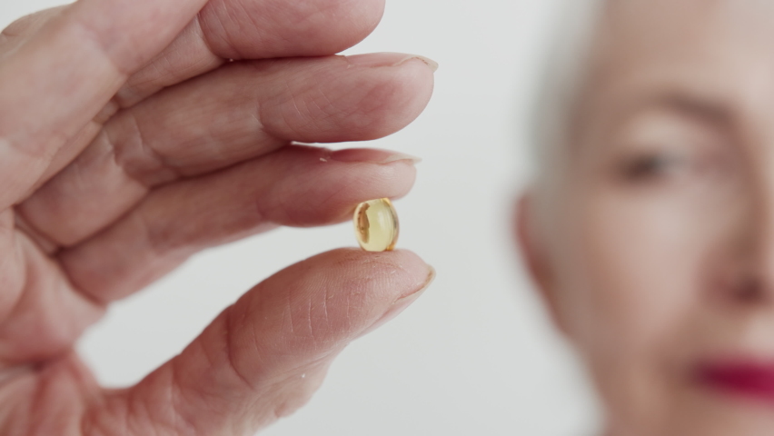 One Attractive Aging Woman Take in Hand Pill and Looking at her Close-up. Portrait Aged 60s Lady Holding Medicine Capsule. Concept Old Human and Healthy Quality Life. Analyzing and Industry Medication | Shutterstock HD Video #1078545371