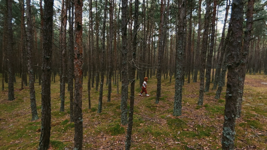 Toddler baby boy in bear bonnet standing in the woods