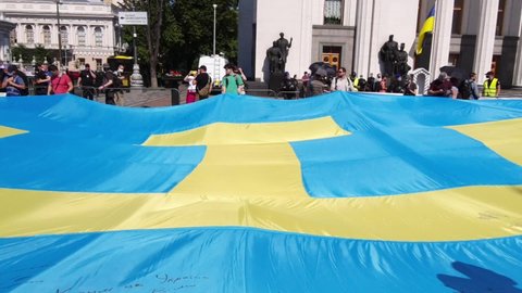 Crimean Tatar flag was unfurled near Verkhovna Rada, Ukraine. Patriotic Tatars from Crimea hold a large blue flag with yellow tanga emblem near Ukrainian parliament, patriot Ukraine, Kyiv, 2021-06-15