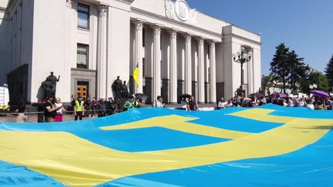 Crimean Tatar flag was unfurled near Verkhovna Rada, Ukraine. Patriotic Tatars from Crimea hold a large blue flag with yellow tanga emblem near Ukrainian parliament, patriot Ukraine, Kyiv, 2021-06-15