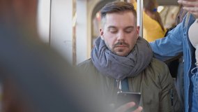 Im ill. Caucasian young guy wearing scarf coughing and talking with somebody on the mobile phone while sitting near the window in the tram or bus. Transportation during pandemic concept - Powered by Shutterstock - Get 15% off with code: PIKWIZARD15