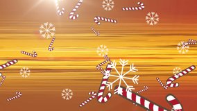 Animation of candy cane and snow falling over glowing rays on orange background. christmas, tradition and celebration concept digitally generated video.