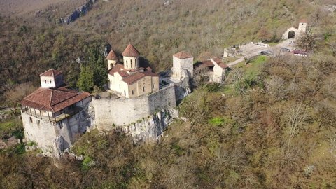 Picturesque aerial view in spring day of Orthodox Motsameta monastery on wooded cliff in curve of Tskaltsitela river near Kutaisi at Imereti region, Georgia. High quality 4k footage