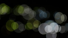 Bokeh video background of light circles on black. Lense light leaks effect. 