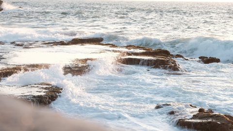 A wild, rocky beach basin, where waves hits the rocks vigorously at the afternoon light. a 4K video clip, Jaffa Beach, Israel.