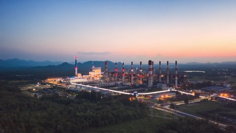 Hyper lapse 4K video, aerial view over coal-fired power plant at sun dawn with smoke from cooling, natural power, air environment and industrial concept.