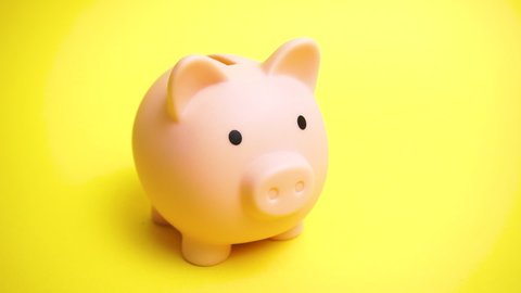 Piggy moneybox at yellow background