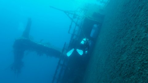 Scuba diver swims near shipwreck Swedish ferry MS Zenobia. Wreck diving. Mediterranean sea, Cyprus
