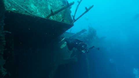 Scuba diver photographer swims on the shipwreck Swedish ferry MS Zenobia. Wreck diving. Mediterranean sea, Cyprus